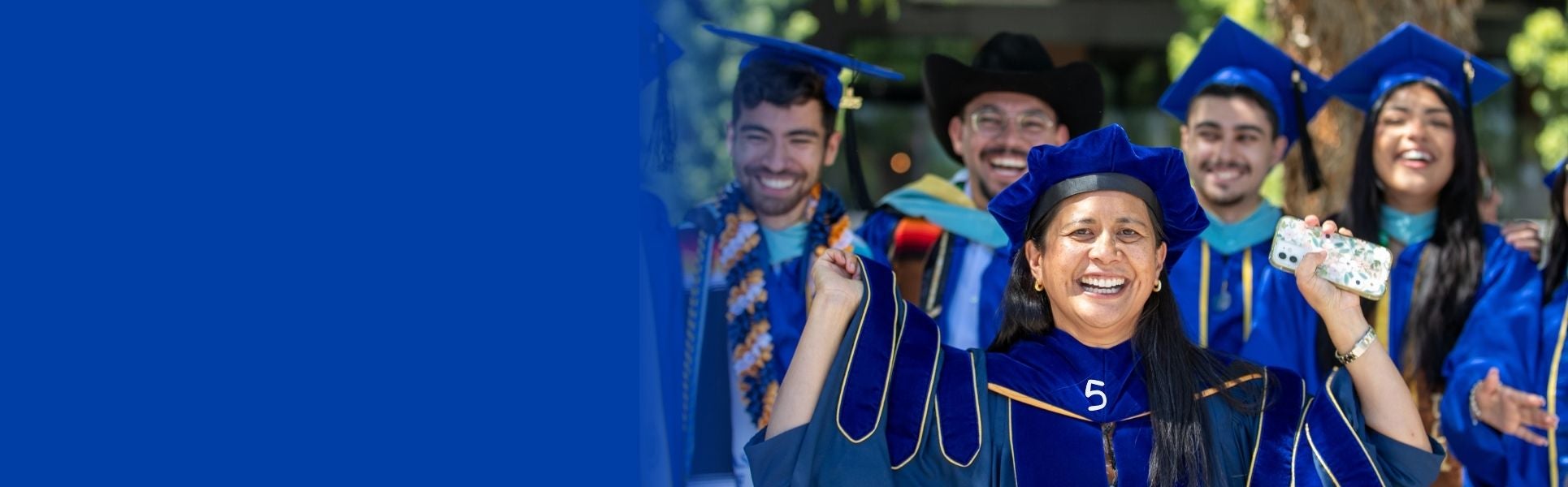Students smiling in graduation cap and grown